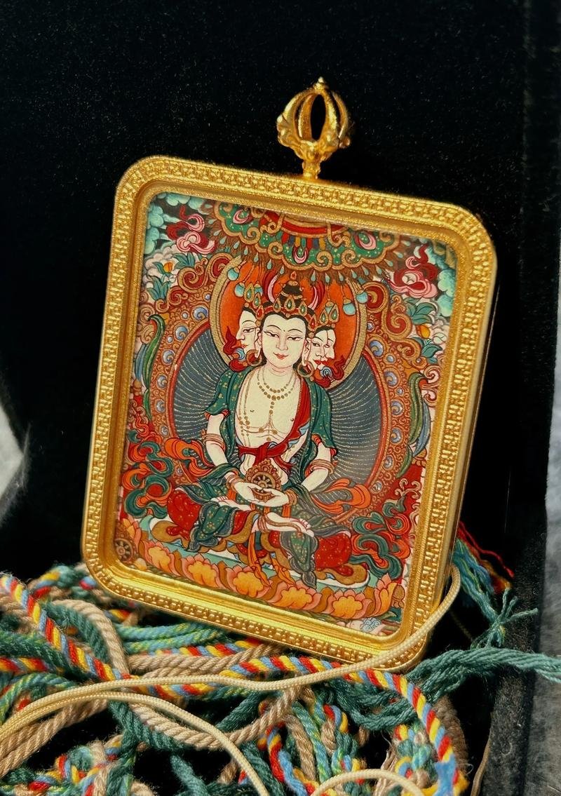 Hand-painted thangka gau pendant — triple-faced deity miniature in a gold-tone copper case with vajra finial and braided cord