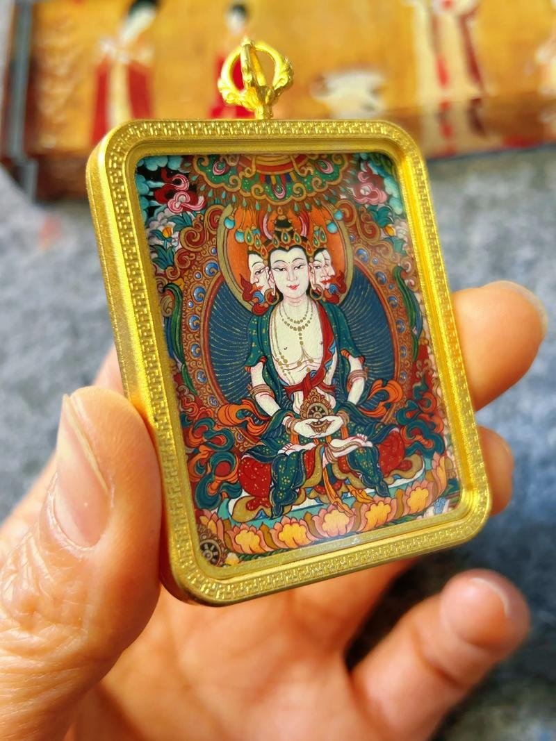 Hand-painted thangka gau pendant held in hand, showing the wearable scale of the copper amulet case